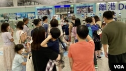 在香港国安法实施满一周年之际,香港民众在机场离境时与家人挥手道别(美國之音 / 湯惠芸)