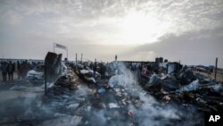 2024年5月27日,以色列袭击加沙地带拉法后,巴勒斯坦人目睹流离失所者所居住地区遭到破坏。(美联社照片)