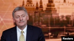 FILE - Kremlin spokesman Dmitry Peskov listens during Russian President Vladimir Putin's annual end-of-year news conference in Moscow, Russia, Dec. 19, 2019.