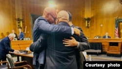 听证会后,老纳尔森·威尔士,哈里森·李和蒂姆‧亨特紧紧拥抱