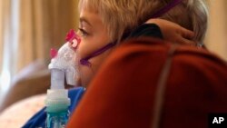 In this Tuesday, Oct. 15, 2013 photo, Carter Howard sits and watches a cartoon during his asthma treatment at his home in Northbrook, Ill.