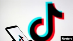 资料图片：在这张拍摄于2019年11月7日的插图中，一个人拿着带有Tik Tok标志的智能手机。（路透社）