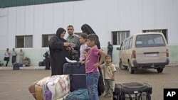 一个巴勒斯坦家庭周六等待跨过拉法边境站,进入埃及