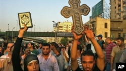 10月10日在开罗街头,一位穆斯林妇女高举可兰经,表示与参加抗议的科普特基督徒保持团结