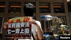 香港一名抗议者举牌反对港版国安法,号召七一游行。(2020年6月30日)