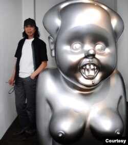 高兟2008年在巴黎个展上与雕塑《毛小姐》合影。(照片高强提供)