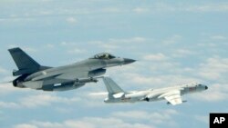 Tư liệu: Ảnh do Bộ Quốc phòng Đài Loan cung cấp, chụp một chiến đấu cơ của Đài Loan, trái, bay gần một máy bay thả bom của TQ bay trên không phận deo biển Luzon ở phía Nam Đài Loan ... chụp ngày 11/5/2018. (Ministry of National Defense via AP)