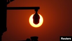 资料照:北京天安门广场上监控摄像头后的朝阳(2019年10月1日)