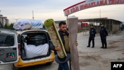 生活在土耳其的叙利亚人携带家当抵达奥库皮纳尔过境点,准备进入叙利亚。(2023年12月11日)