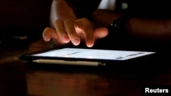 Một người đàn ông dùng Ipad tại một tiệm cà phê Internet tại Hà Nội, ngày 18/5/2021.