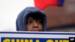 菲律宾一名华裔市长郭华萍涉嫌与中国犯罪集团往来,因为缺席听证会遭参议院下令逮捕,此案在马尼拉和北京关系紧张之际引起菲律宾全国关注。图为7月12日一名菲律宾示威者举着标语庆祝南中国海仲裁裁决 8 周年。