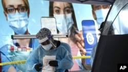 佛州的医护人员正在迈阿密的一个新冠病毒检测点工作。(2020年11月18日)