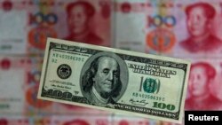 100元人民币衬托下的100美元纸币。