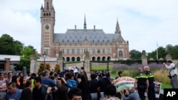 海牙国际仲裁庭宣布裁决结果之前,海牙和平宫外面聚集着示威者、警察和记者(2016年7月12日)