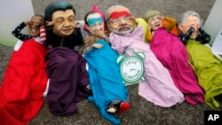 Активісти Oxfam одягнені в маски лідерів США, Китаю, Франції, Індії, Німеччини, Австралії, щоб привернути їхню увагу 