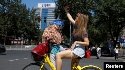 资料照片:一位女士在北京中兴通讯公司大楼附近自拍。(2018年8月29日)