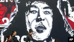 北京街头的学雷锋宣传画。几个行人从画前走过 (2003年)资料照片