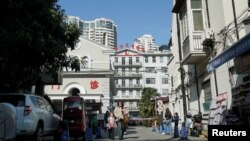 资料照:一名女子手拉着一个孩子走出上海市儿童医院。 (2023年11月24日)