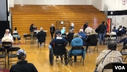 资料照片:以老人为主的民众在马里兰州蒙哥马利郡由某高中体育馆临时改建的新冠疫苗接种中心接种疫苗后坐在观察区内。(2021年3月22日)