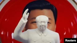 北京天安门附近一个纪念品商店里毛泽东的塑像摆在习近平纪念画盘的前面。(2018年3月1日)