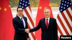 美国财政部长姆努钦(左)和中国副总理刘鹤在北京钓鱼台国宾馆举行美中高级别贸易谈判前握手。(2019年2月14日)