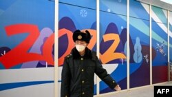 资料照片:在2022年北京冬季奥运会开幕前,一名中国安保人员在张家口太子城站的“闭环管理”“泡泡”区域内引导到达的乘客。(2022年1月29日)