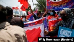 Activists hold placards and banners during a protest to support the anti-coup movement and democracy in Myanmar, near the Association of Southeast Asian Nations (ASEAN) secretariat building, ahead of the ASEAN leaders' meeting in Jakarta, Indonesia April