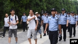 资料照:中国网络理财民间集资受害者在北京被警察和保安人员带出公园,送上大巴拉走(2018年8月6日)。