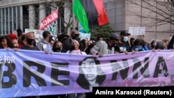 资料照片:人们在肯塔基州路易维尔集会,纪念一年前被警察破门而入并开枪打死的布伦娜·泰勒。(2021年3月13日)