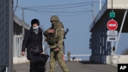 在乌克兰东部的新特罗伊茨克,一位女子从俄罗斯支持的分离主义控制区经过一处检查站,进入乌克兰政府军控制区。(2022年2月21日)