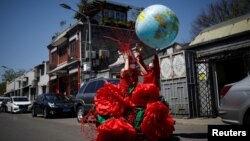 一名艺术家在北京的蓝天下庆祝“地球日”。(2020年4月22日)