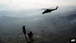 FILE - A military helicopter flies over the VRAEM region, in Pichari, Peru, Sept. 19, 2014. The region in the Apurimac, Ene and Mantaro river valleys, or VRAEM, is the world's No. 1 coca-growing region.