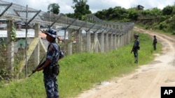 档案照 - 2018年6月29日,缅甸边防人员在缅甸与孟加拉国之间的无人区附近站岗提供安全保障,地点位于若开邦北部貌昂道陶漂拉提亚村附近。