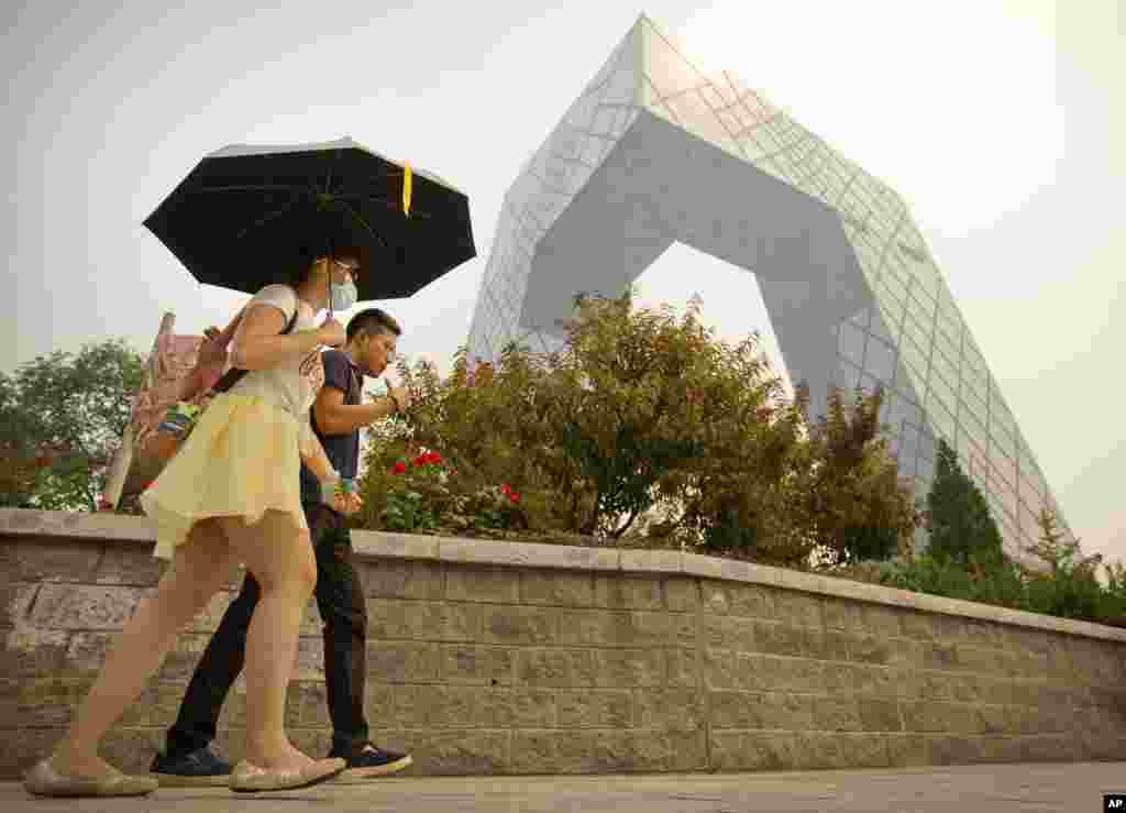 有人打雨伞戴口罩从北京中央电视台大楼旁走过(2015年)。在外界猜疑声中,央视在2017年播出报道《海航24年前行的力量》。海航网站介绍这个节目说,它讲述了海航从“那个春天,是万物生长的季节,几个南下的年轻人,在中国最年轻的省份,开始了他们的创业梦”,到用胆识、智慧和分享的理念开启国际化发展,成长为全球大型企业集团的发展历程。