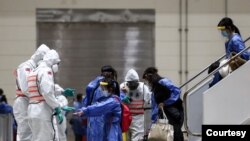 台湾防化兵在对从武汉飞抵桃园机场包机的台湾人进行防疫消毒作业。(台湾国防部军闻社提供)