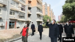 中国国家主席习近平在视察武汉一个居民区时向被隔离的居民招手致意。(2020年3月10日)