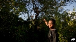 ၂၀၁၃ ခုနှစ်က တပ်ပြေး ကလေးစစ်သားတဦး သူ ရက်ပေါင်းများစွာ ပုန်းအောင်းခဲ့ရာ သစ်ပင်များကို ပြန်လည်ပြသနေစဉ်။