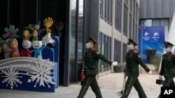 中国武警士兵在北京冬奥会吉祥物前走过。(2022年1月21日)