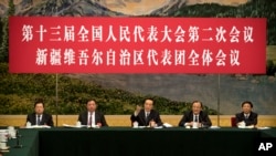 2019年3月12日在北京人民大会堂举行的全国人大会议新疆维吾尔自治区代表团会议上,新疆党委书记陈全国(中)讲话。讲台上的人前面都没有名牌。