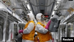 韩国工人为了防疫给首尔地铁车厢消毒。(2020年3月11日)