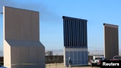 Three of U.S. President Donald Trump's eight border wall prototypes are shown near completion along U.S.- Mexico border in San Diego, California, Oct. 23, 2017.