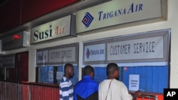 Trigana လေကြောင်းခရီးစဉ်မှာ ပါသွားသူတွေရဲ့ ဆွေမျိုးတွေ Sentani လေဆိပ်က ပိတ်ထားတဲ့ ရုံးခန်းရှေ့မှာ လာရောက်စောင့်ဆိုင်းနေစဉ်။ (သြဂုတ် ၁၆၊ ၂၀၁၅)