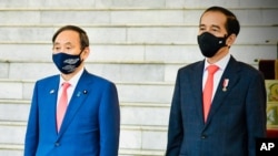 日本首相菅义伟(左)和印尼总统佐科·维多多在总统府会晤时奏国歌。(2020年10月20日)