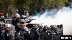 在曼谷政府大厦附近发生的冲突中,泰国防暴警察把武器对准反政府示威者。(2014年2月18日)