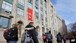 FILE - Students and passers-by walk past an entrance to Boston University College of Arts and Sciences, in Boston, Massachusetts, Nov. 29, 2018.