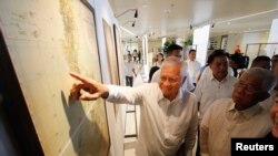 Ngoại trưởng Philippines Albert Del Rosario chỉ vào một bản đồ cổ trên màn hình bên cạnh Bộ trưởng Quốc phòng Voltaire Gazmin tại trường đại học Công giáo ở Manila (ảnh tư liệu năm 2014). Chính quyền của Tổng thống Philippines sắp rời nhiệm sở Benigno Aquino đã quyết định đưa Trung Quốc ra tòa đầu năm 2013.