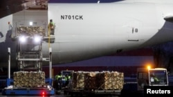 资料照:乌克兰基辅郊外的鲍里斯波尔国际机场的工作人员从飞机上卸下一批美国对乌克兰的军事援助物资。(2022年2月5日)