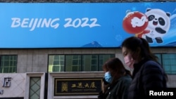 资料照:人们走过北京冬奥会的宣传标语。