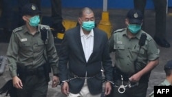 资料照片:香港民主派媒体大亨、《苹果日报》创始人黎智英被带上警车前往法庭,