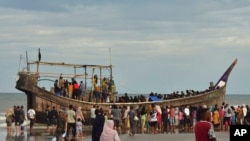 当地居民在印尼亚齐省的海滩上检查一艘载有罗兴亚难民的船只。(美联社:2025年1月29日)